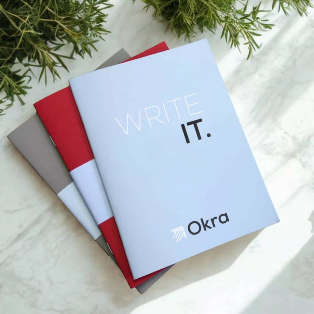 Carnet personnalisé avec couverture écrite "WRITE IT" et logo Okra.