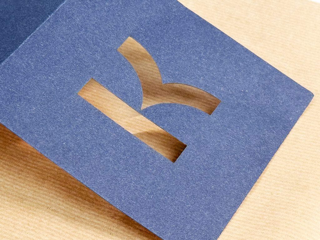 Logo découpé sur boîte en carton kraft bleue.